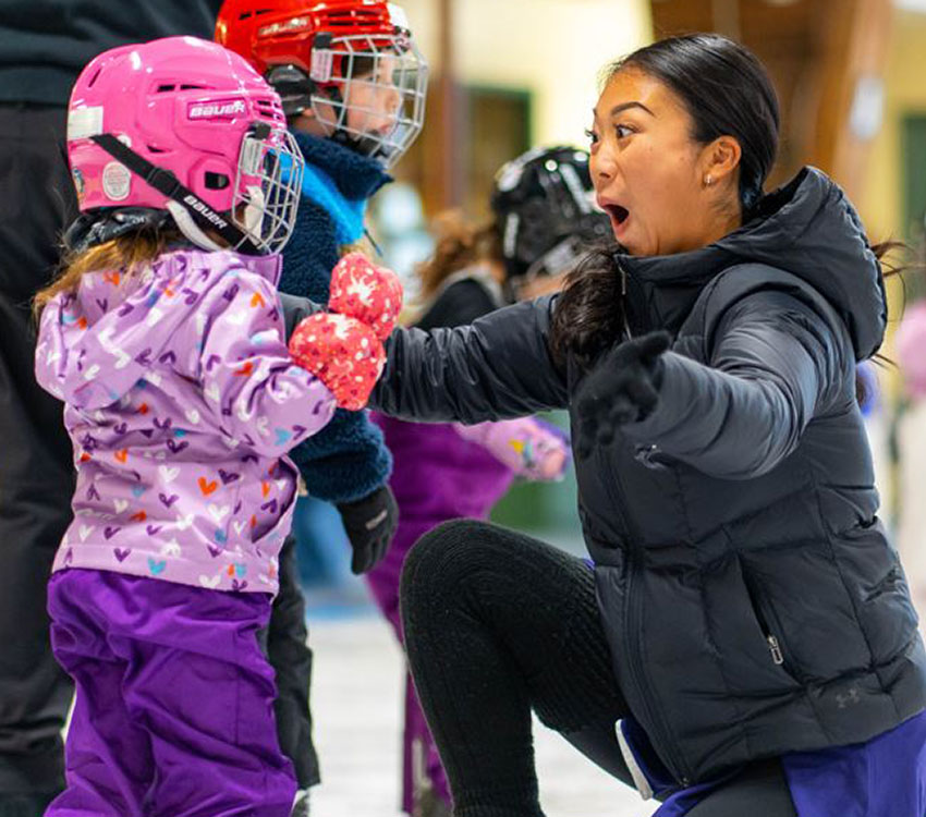 A Skating coach celebrating with a young skater.